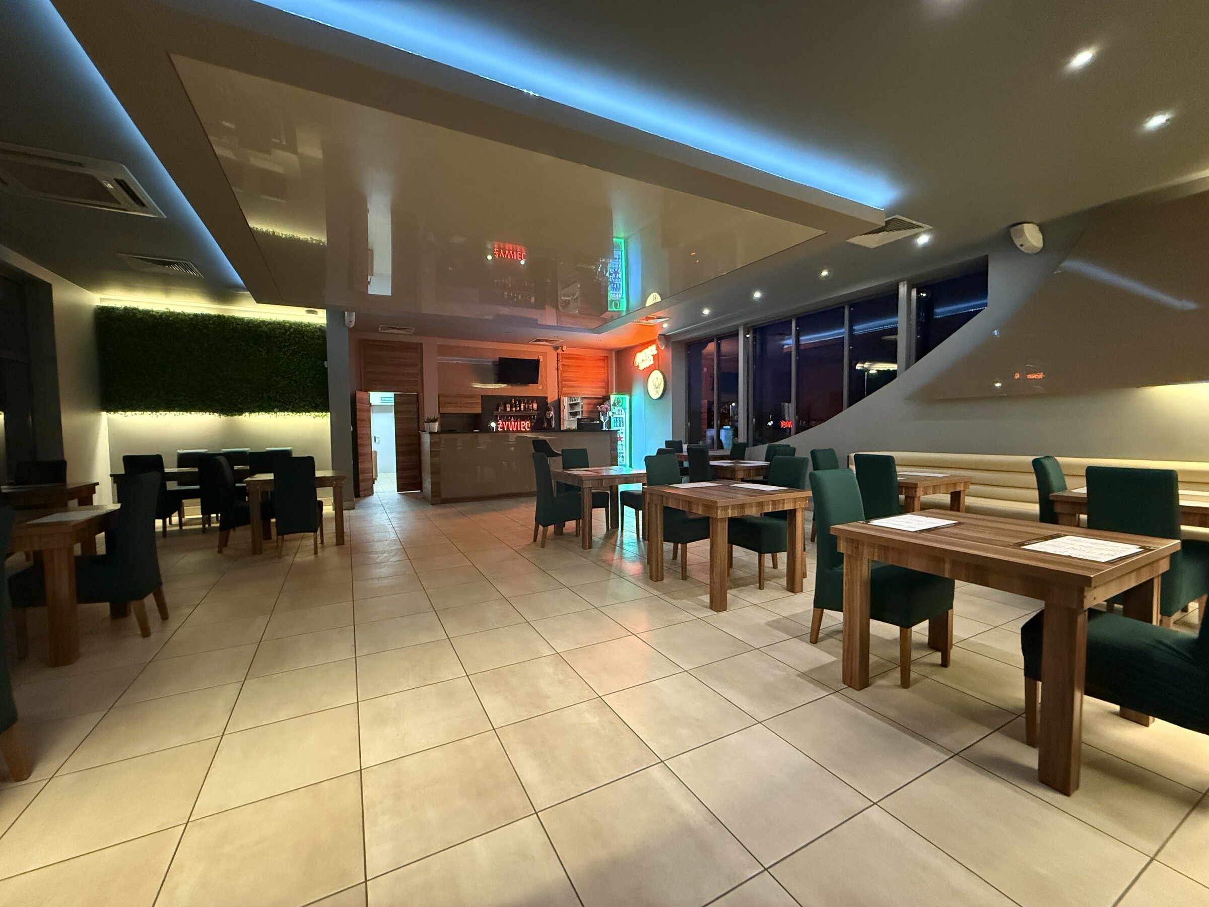 Sala restauracyjna Panorama wieczorem, widoczny bar i nakryte stoliki